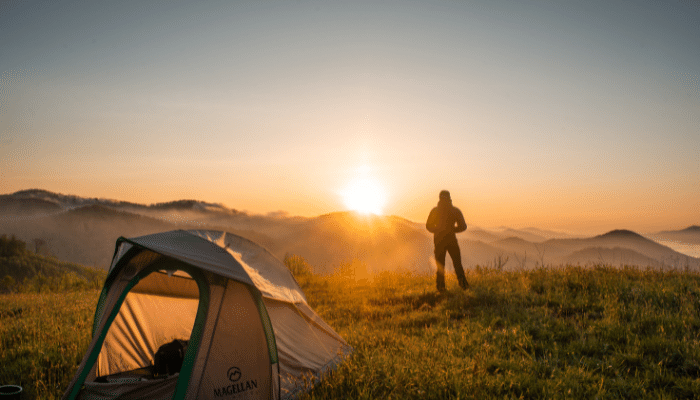 ser un agente de cambio comunidad ESTAR Escuela de sostenibilidad turística argentina persona mirando el horizonte en un amanecer acampando en la montaña